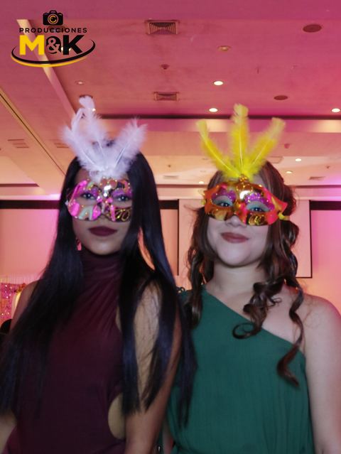Dos amigas con antifaces de plumas