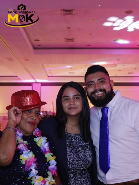 Tres invitados con sombrero rojo, collar de flores y corbata brillante