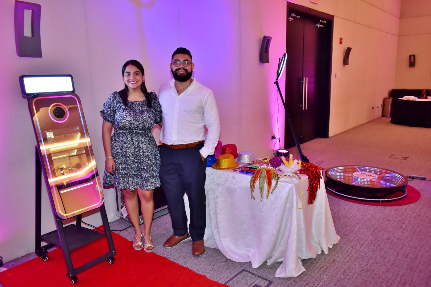 Maurem y Kenneth de Producciones M&K junto al fotomatón espejo, la mesa de accesorios y el fotomatón 360°
